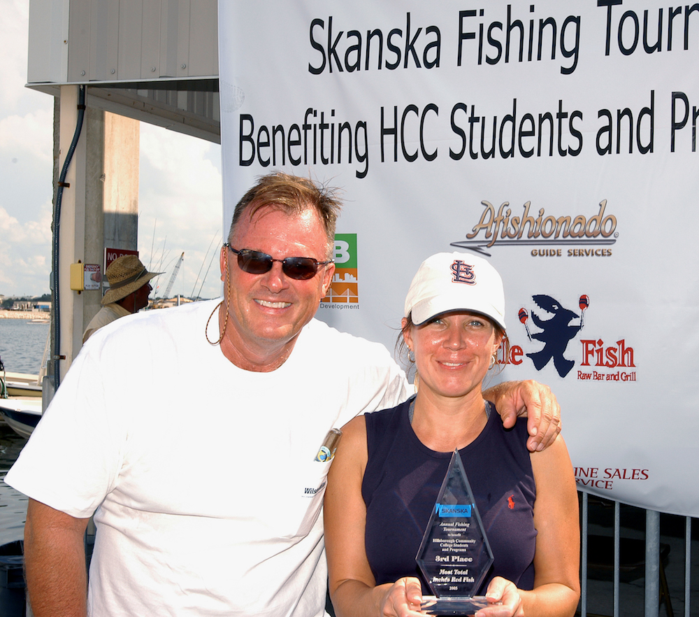 a man wearing sunglasses and a white shirt with his arm around another person wearing a white cap and navy blue top